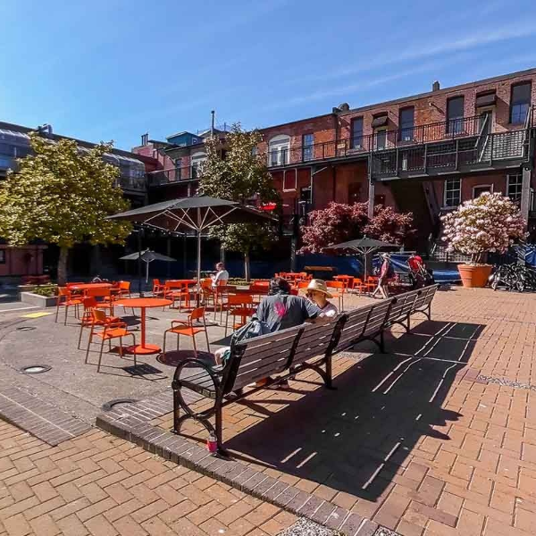 People sitting on a park bench at Market Square Victoria